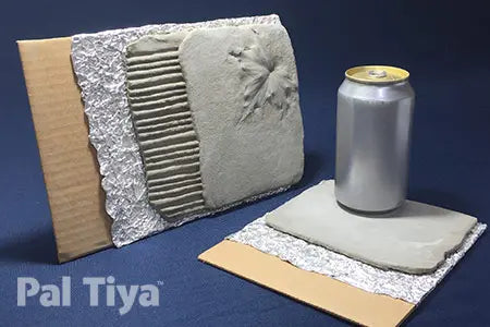 Two Pal Tiya clay tiles shown on a dark blue background, one standing upright with a textured floral design and one lying flat with a small silver can placed on top for scale. A Pal Tiya logo is visible in the lower left corner.