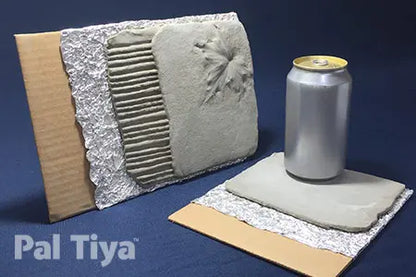 Two Pal Tiya clay tiles shown on a dark blue background, one standing upright with a textured floral design and one lying flat with a small silver can placed on top for scale. A Pal Tiya logo is visible in the lower left corner.